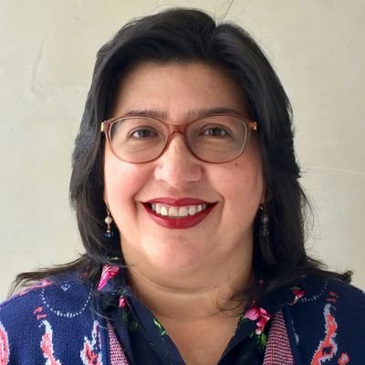 Mujer con gafas y camisa azul sonriendo