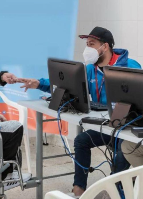 En la imagen una persona atendiendo detrás de un escritorio