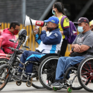 Personas en silla de ruedas con parlante en un evento